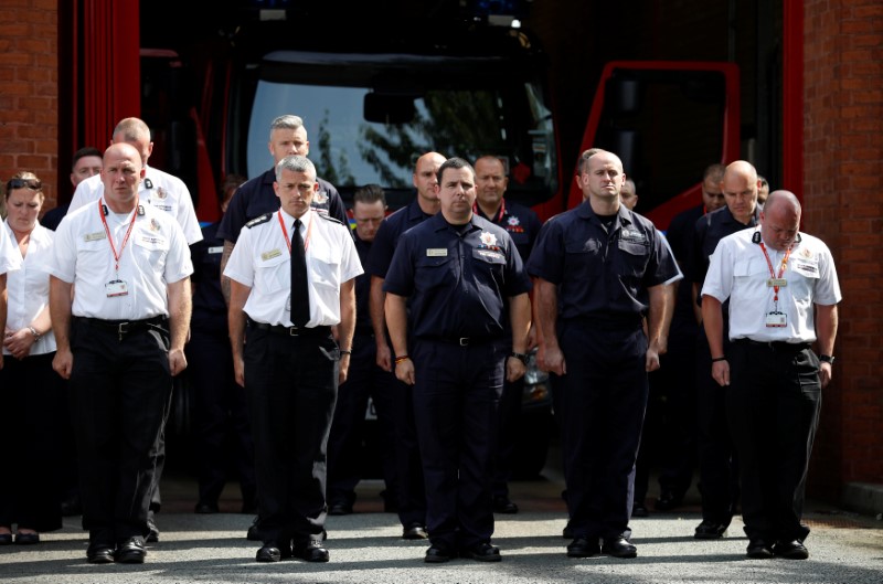 Firefighters from the Manchester Central Community Fire Station observe a minute's silence in memory of the victims of the fire that destroyed London's Grenfell Tower block, in Manchester on June 19, 2017. (REUTERS/Phil Noble)