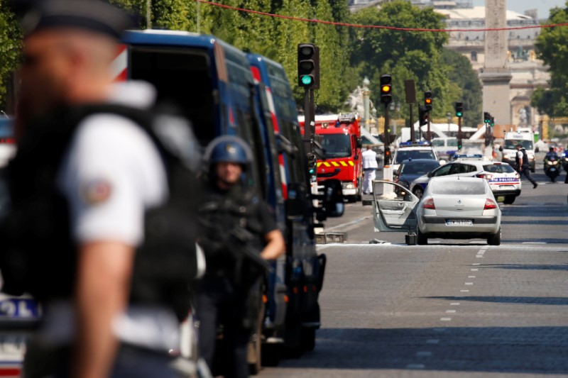 French policemen secure the area around a burned car on the Champs Elysees avenue after an incident in Paris, France, June 19, 2017. REUTERS/Gonzalo Fuentes