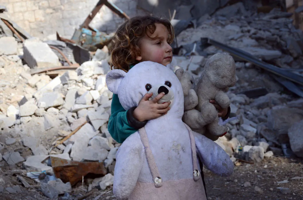 A Syrian girl, holding her stuffed toy, stands next to the rubble of buildings in the northwestern Syrian border town of al-Bab on February 25, 2017 (Nazeer Al-Khatib/AFP/Getty Images)