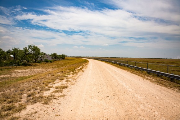 The levee road behind the tiny border town of Granjeno, Texas, on May 28, 2017. The levee drops about 18 feet to the right, and Granjeno is situated to the left. (Benjamin Chasteen/The Epoch Times)