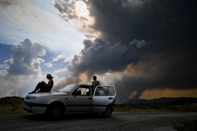 People watch the columns of smoke rising from a wildfire in Gois, Portugal, on June 20, 2017. (PATRICIA DE MELO MOREIRA/AFP/Getty Images)