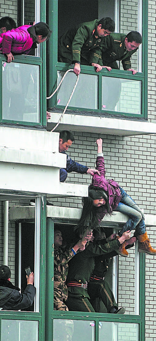 A Chinese woman who attempted to jump off the 33rd floor of an apartment building in Changsha, in China's Hunan Province, on Feb. 28, 2012. (STR/AFP/GETTY IMAGES)