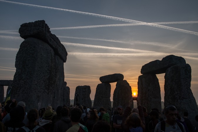 Revelers watch the sunrise as they celebrate the pagan festival of Summer Solstice at Stonehenge in Wiltshire, England, on June 21, 2017. The festival, which dates back thousands of years, celebrates the longest day of the year when the sun is at its maximum elevation. (CHRIS J RATCLIFFE/AFP/Getty Images) 
