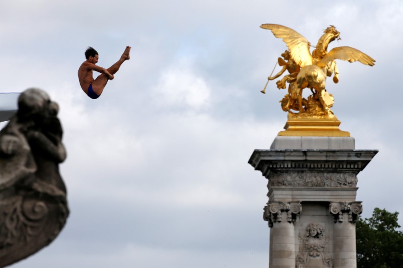 A diver performs from the Pont Alexandre III bridge into the River Seine in Paris, France, June 23, 2017 as Paris transforms into a giant Olympic park to celebrate International Olympic Days with a variety of sporting events for the public across the city during two days as the city bids to host the 2024 Olympic and Paralympic Games.  REUTERS/Jean-Paul Pelissier     TPX IMAGES OF THE DAY