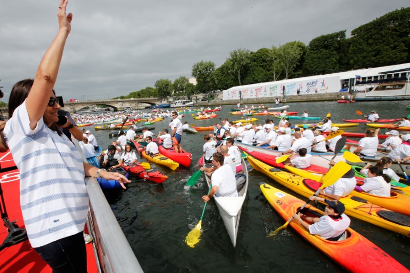 Paris Mayor Anne Hidalgo waves to kayakers on the River Seine in Paris, France, June 23, 2017 as Paris transforms into a giant Olympic park to celebrate International Olympic Days with a variety of sporting events for the public across the city during two days as the city bids to host the 2024 Olympic and Paralympic Games.  REUTERS/Jean-Paul Pelissier/POOL