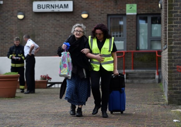 A resident is evacuated from the Burnham Tower residential block as a precautionary measure following concerns over the type of cladding used on the outside of the building on the Chalcots Estate in north London, Britain, June 24, 2017. (Reuters/Hannah McKay)