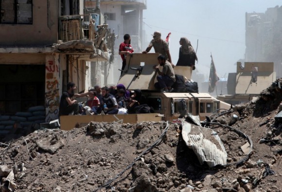 Displaced people who fled from clashes ride in a military vehicle of Iraqi security forces, in the Old City of Mosul, Iraq June 24, 2017. (Reuters/Azad Lashkari)