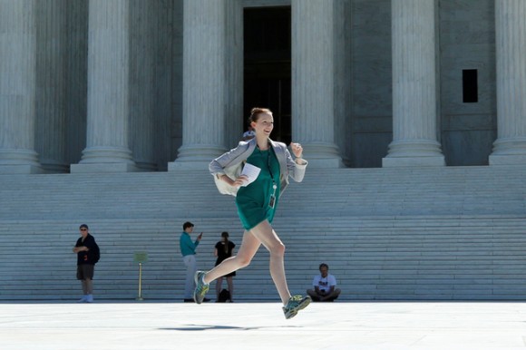 A news assistant runs out after the U.S. Supreme Court granted parts of the Trump administration's emergency request to put his travel ban into effect immediately while the legal battle continues, in Washington, U.S., June 26, 2017. REUTERS/Yuri Gripas