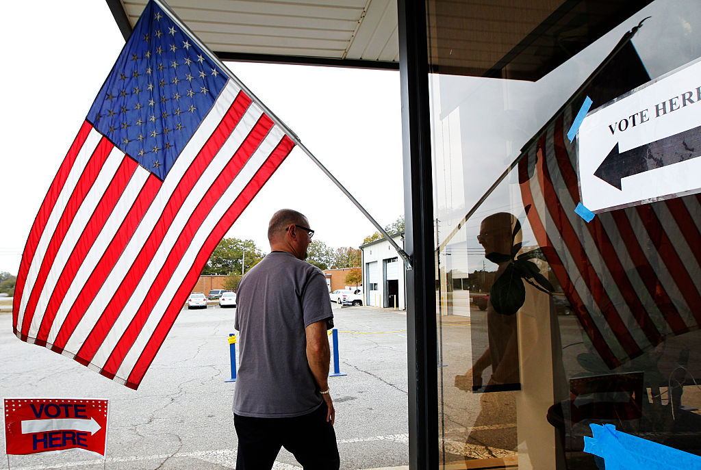 A voter walks past a US flag as he heads in to vote in the US presidential election at the Athens-Clarke County Fleet building in Athens, Georgia on Nov. 8, 2016. (TAMI CHAPPELL/AFP/Getty Images)