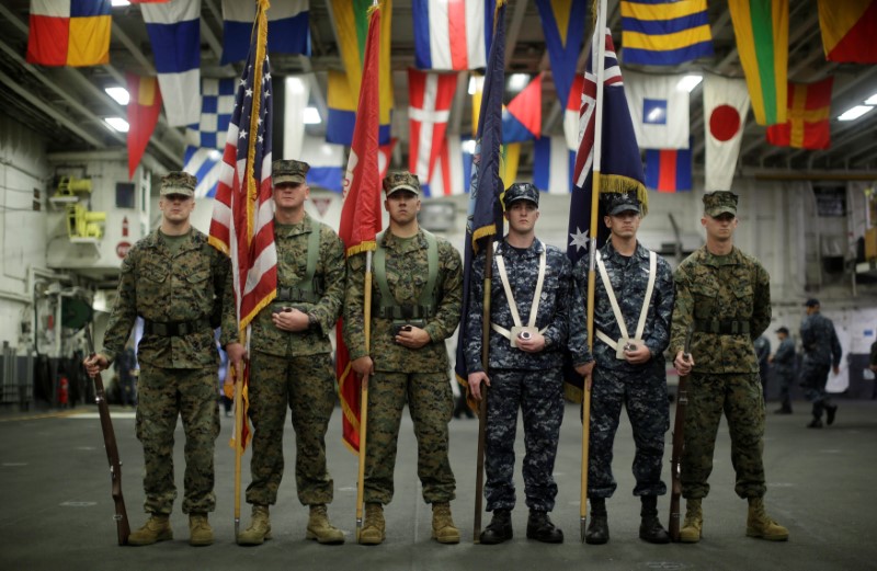 A flag party of U.S. Marines and Navy personnel take part in a ceremony marking the start of Talisman Saber 2017, a biennial joint military exercise between the United States and Australia aboard the USS Bonhomme Richard amphibious assault ship on the the Pacific Ocean off the coast of Sydney, Australia, June 29, 2017.    REUTERS/Jason Reed