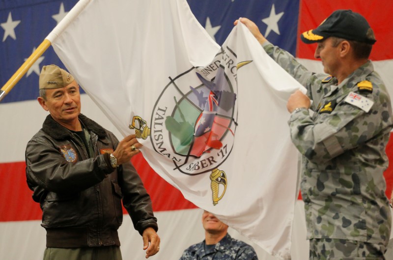 U.S. Navy Admiral Harry Harris, Commander of the U.S. Pacific Command, and Australian Navy Vice Admiral David Johnston unfurl the flag for Talisman Saber 2017, a biennial joint military exercise between the United States and Australia, aboard the USS Bonhomme Richard amphibious assault ship in the Pacific Ocean off the coast of Sydney, Australia, June 29, 2017. REUTERS/Jason Reed