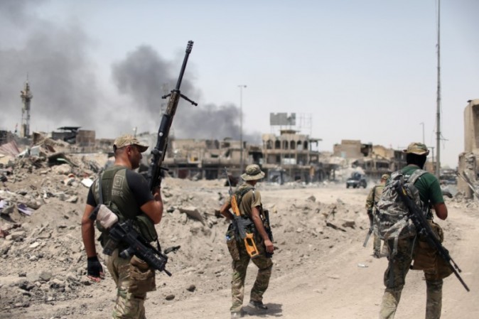 Members of the Emergency Response Division walk with their weapons during the fight with the Islamic States militants in the Old City of Mosul, Iraq, July 3, 2017. (REUTERS/Ahmed Jadallah)