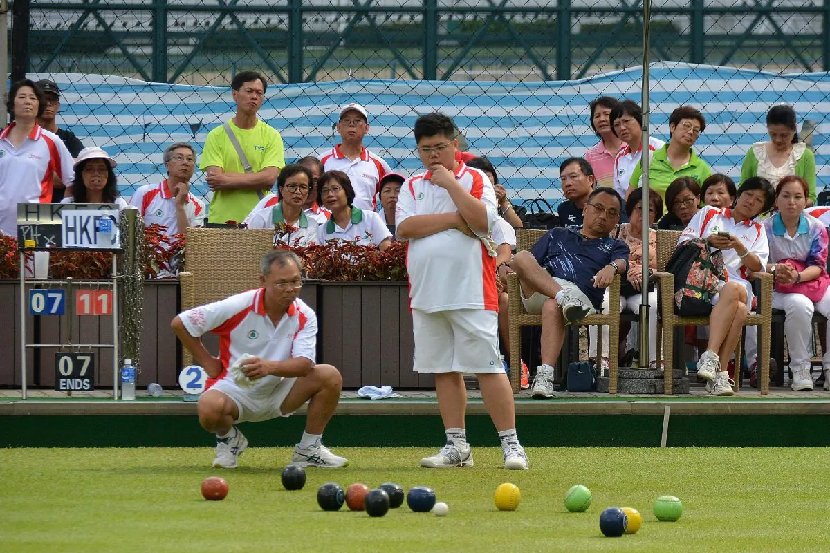 Hong Kong Football Club’s Anthony Yip (standing) on his way to defeating Esmond Lee from Phoenix in the final of the Reunification Cup on July 2. Stephanie Worth)