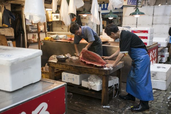 Fishermen slice up a fish at the Tsukiji market. (Annie Wu/The Epoch Times)