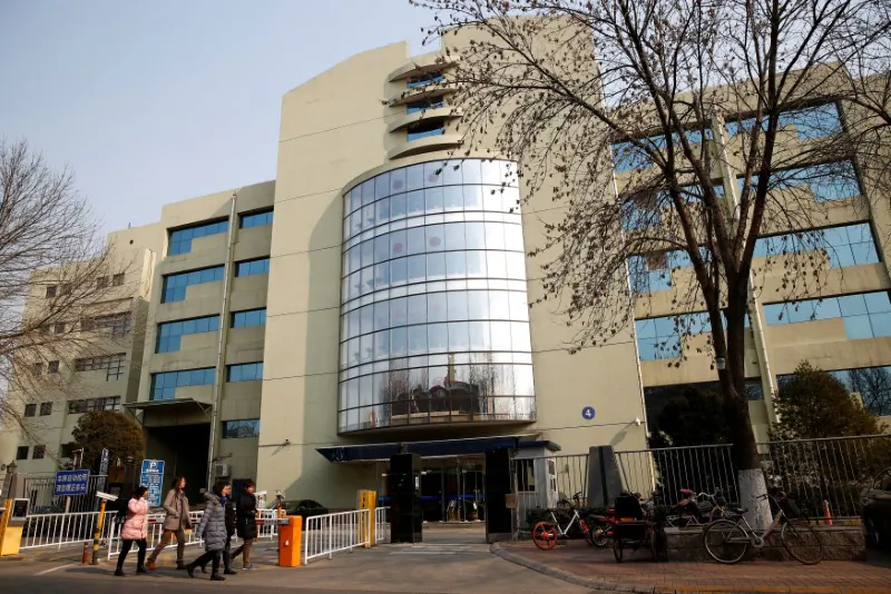 People walk past the building with the listed address of Tomorrow Holdings' Beijing office, China on Feb. 3, 2017. (REUTERS/Thomas Peter)