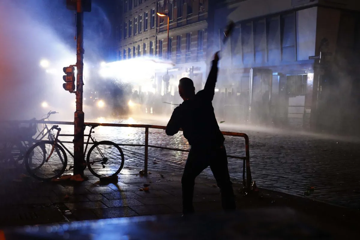 A protester throws a bottle towards riot police during demonstrations at the G20 summit in Hamburg, Germany, July 8, 2017. (Reuters/Fabrizio Bensch)