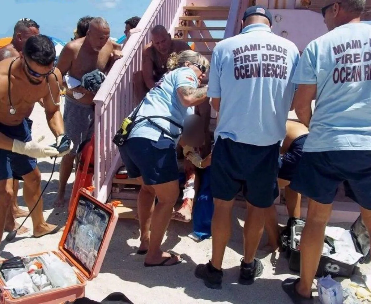 Lifeguards apply First Aid to man bitten by shark just off  beach in south Florida.  (Rob Boyte/Miami-Dade Fire Rescue)