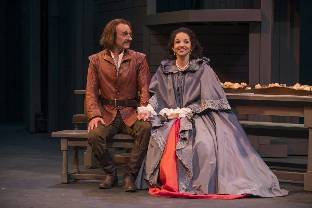 Cyrano (James Ridge) listens in anticipation to hear who his cousin Roxane (Laura Rook) truly loves. (Michael Brosilow)