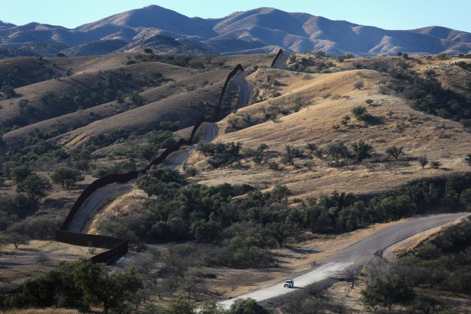A U.S. Border Patrol vehicle drives along the U.S.-Mexico border fence on December 9, 2014 near Nogales, Arizona. (John Moore/Getty Images)