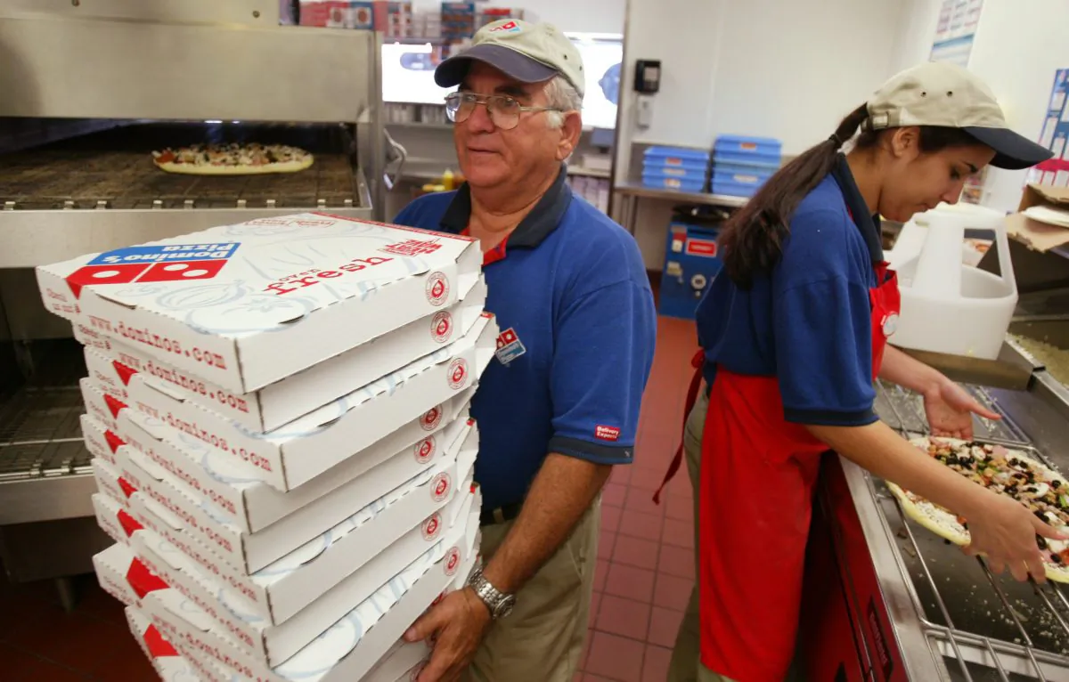 Elio Blanco (L) and Yenelis Garcia prepare pizzas at Domino's Pizza in Miami, Fla., on April 14, 2004. (Joe Raedle/Getty Images)
