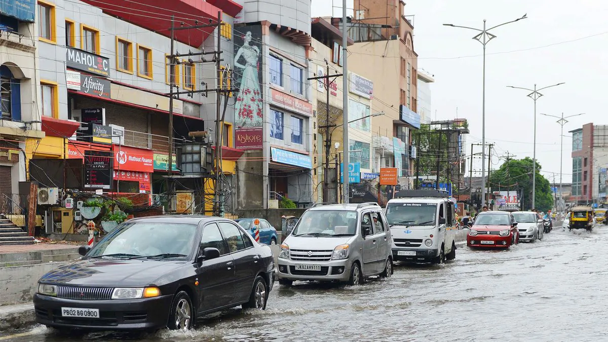 Indian commuters make their way along a flooded street after a heavy rain downpour in Amritsar on July 12, 2017. (Narinder Nanu/AFP/Getty Images)