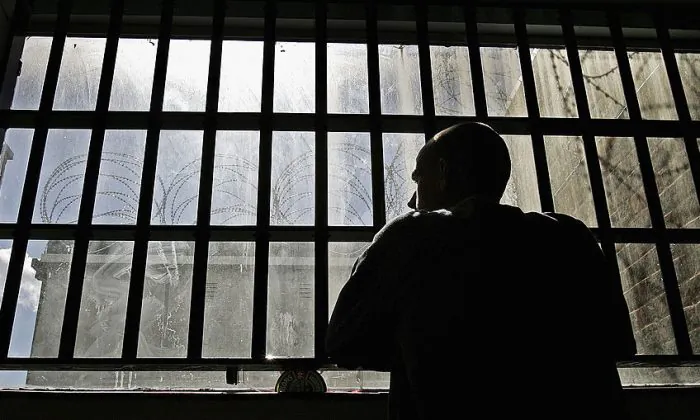 A young inmate looks out from prison bars. (Peter Macdiarmid/Getty Images)