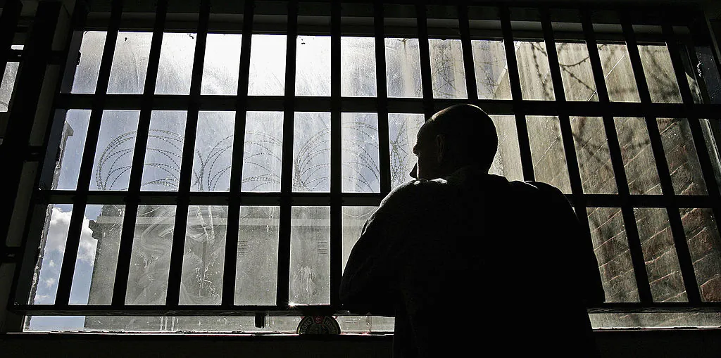 An inmate looks out from prison bars. (Peter Macdiarmid/Getty Images)