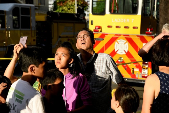 Evacuated residents look up at Marco Polo apartment building after a fire broke out in it in Honolulu, Hawaii, July 14, 2017. (Reuters/Hugh Gentry)