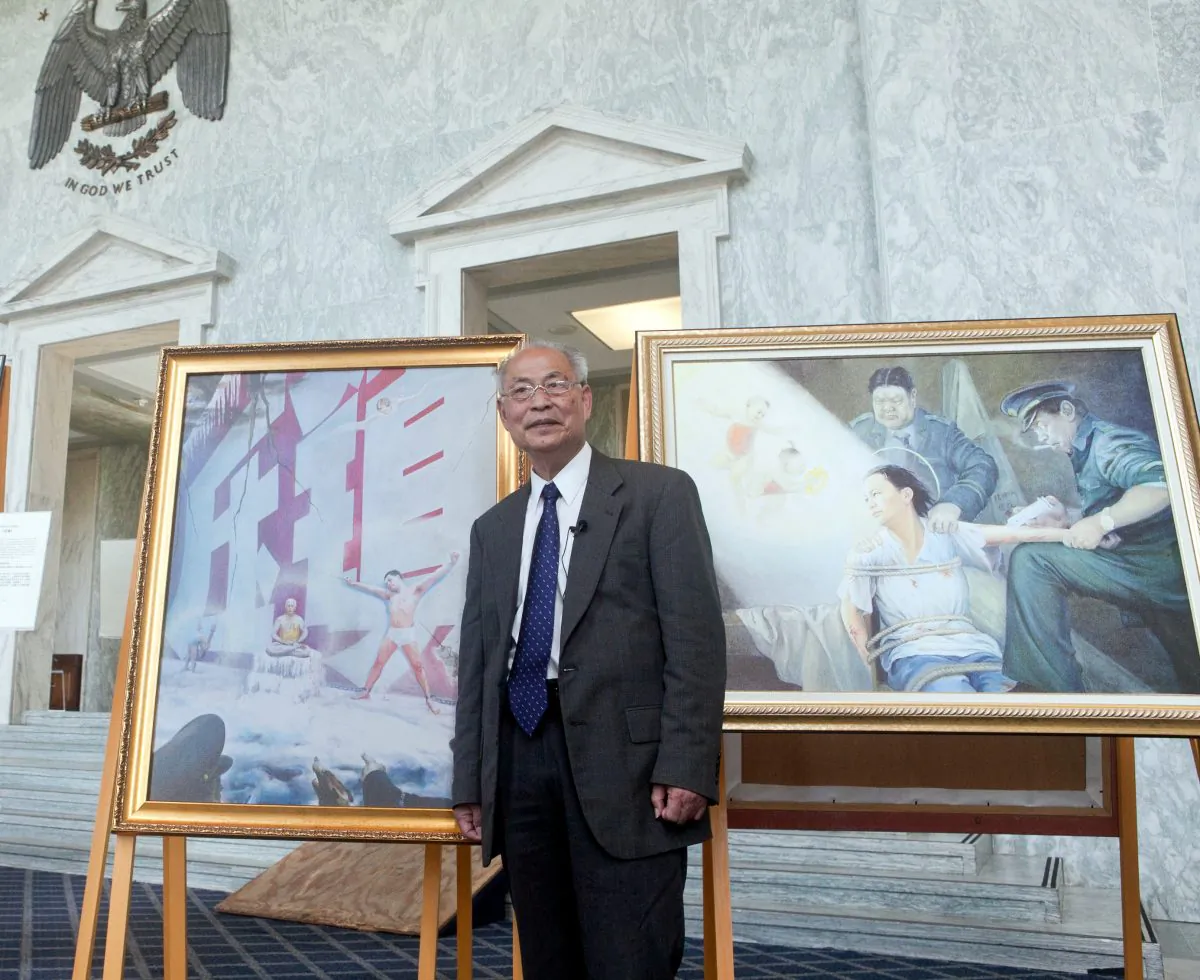 Professor Kunlun Zhang with his painting “Red Wall,” which is based on his experience as a prisoner of conscience in China, at the Art of Zhen Shan Ren International Exhibition in Washington, D.C., on July 18, 2013. Zhang is the general coordinator of the exhibition. (The Epoch Times)