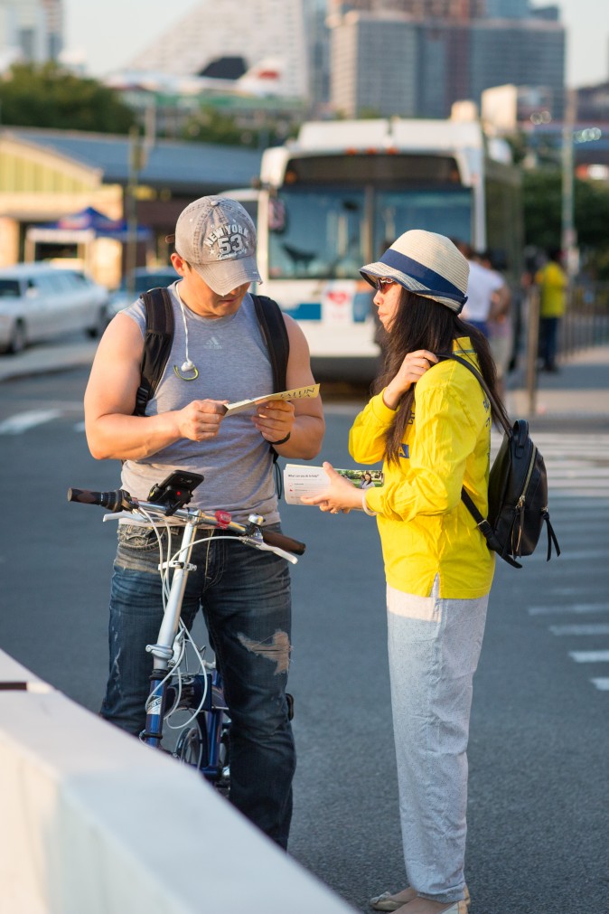 Falun Gong practitioners pass out pamphlets to passerby near the Chinese Consulate in New York on July 16, 2017, about the practice and the persecution that is still happening inside China. (Benjamin Chasteen/The Epoch Times)