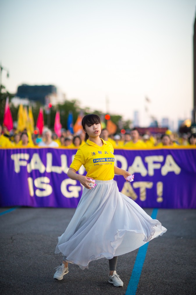 Woman perform a song and dance at a rally in front of Chinese Consulate in New York calling for an end to the Falun Gong persecution inside China in New York on July 16, 2017. (Benjamin Chasteen/The Epoch Times)