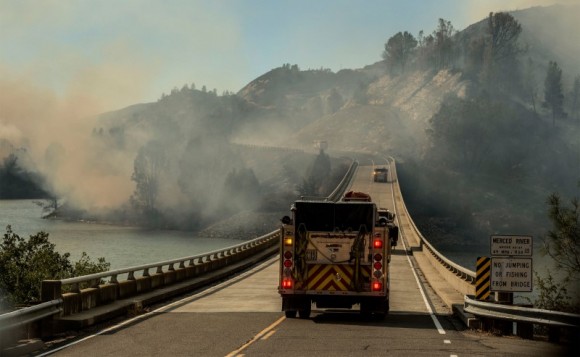 A firetruck drives across the Merced River at the Bagby bridge after authorities ordered evacuations due to the Detwiler fire in Mariposa, California, U.S. July 18, 2017. (Reuters/Al Golub)