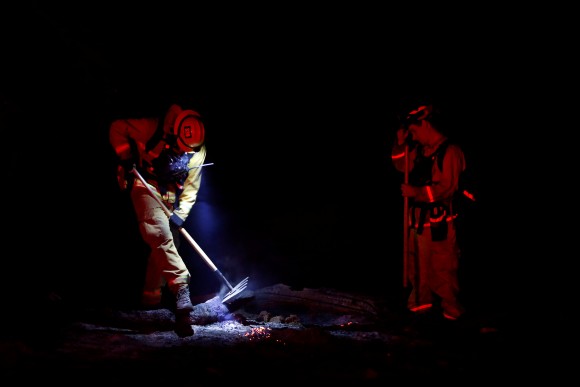 Two firefighters work on a hotspot during the Detwiler fire in Mariposa, California, U.S., July 19, 2017. (Reuters/Stephen Lam)