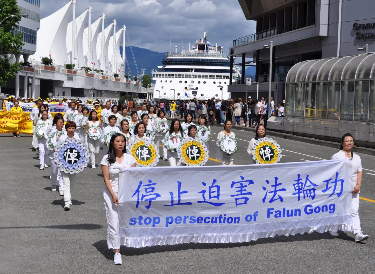 Falun Gong practitioners march in downtown Vancouver on July 16, 2017, to call for an end to the persecution of their spiritual discipline ordered by the Chinese regime 18 years ago on July 20, 1999. A procession of practitioners in white hold memorial wreaths to pay tribute to those who have been persecuted to death. (Tang Feng/The Epoch Times)