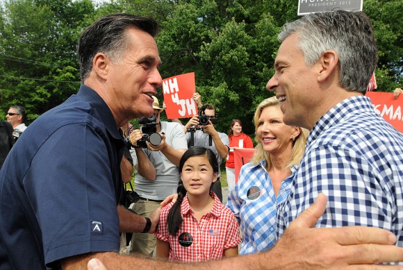 Republican presidential candidates Former Ambassador to China Jon Huntsman (R) and former Massachusetts governor Mitt Romney (L) greet to each other prior to marching in a Fourth of July parade as Huntsman's wife Mary Kaye (2nd R) and daughter Gracie Mei look on July 4, 2011 in Amherst, New Hampshire. (Photo by Darren McCollester/Getty Images)