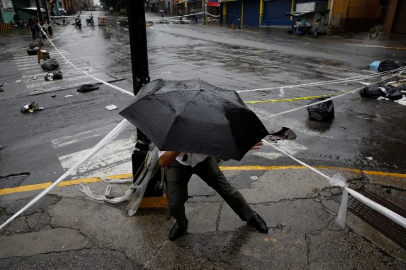 A pedestrian walks through a barricade during a rally against Venezuelan President Nicolas Maduro's government in Caracas, Venezuela, July 19, 2017.  (Reuters/Carlos Garcia Rawlins)