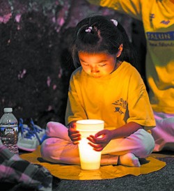A girl attends a candlelight vigil in front of the Chinese Consulate in New York on July 16. (BENJAMIN CHASTEEN/THE EPOCH TIMES)