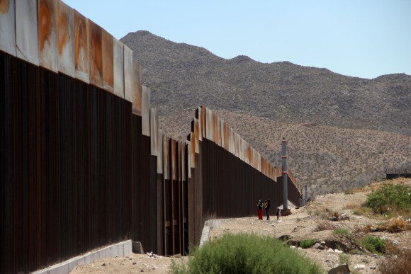 A Mexican family stands next to the border wall between Mexico and the United States, in Ciudad Juarez, Mexico on May 23, 2017. (HERIKA MARTINEZ/AFP/Getty Images)