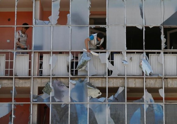 An Afghan man removes fragments of glass from a building after a suicide attack in Kabul, Afghanistan July 24, 2017. (Reuters/Mohammad Ismail)