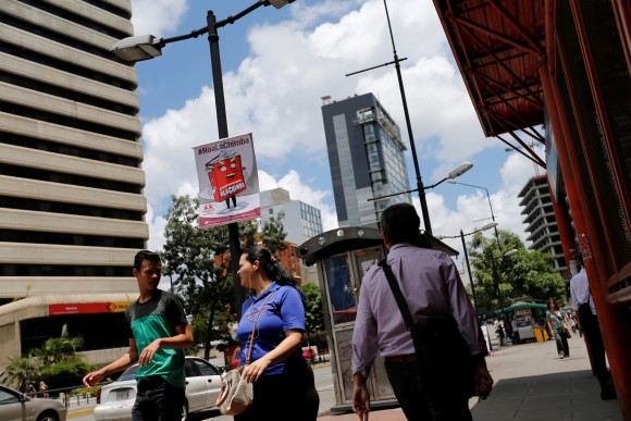 Pedestrians walk past banners against the National Constituent Assembly in a street of Caracas, Venezuela, July 24, 2017. The banner reads "No to fraud". (Reuters/Andres Martinez Casares)