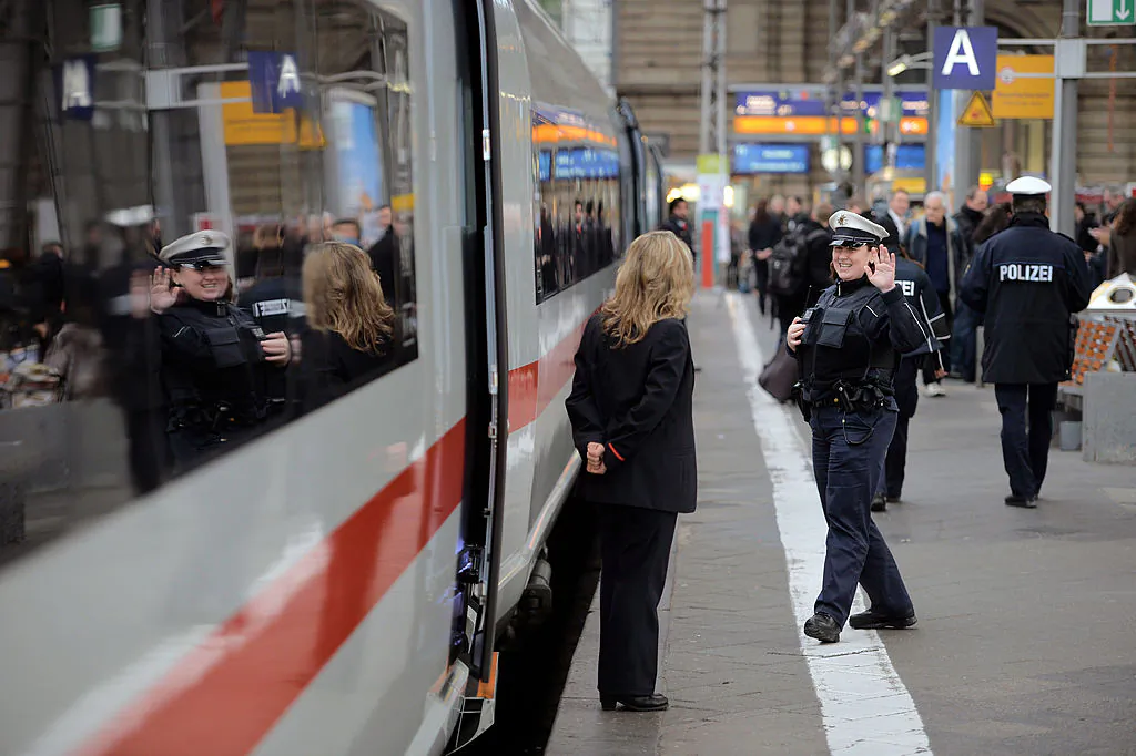 A Train conductor speaks with a policewoman next to the latest generation of the ICE 3 Deutsche Bahn high-speed train during a media presentation on February 18, 2014 at Frankfurt, Germany. The train, built by Siemens, has a top speed of 320km per hour for the admission in France. In Germany the top speed is around 300km per hour.  (Photo by Thomas Lohnes/Getty Images)