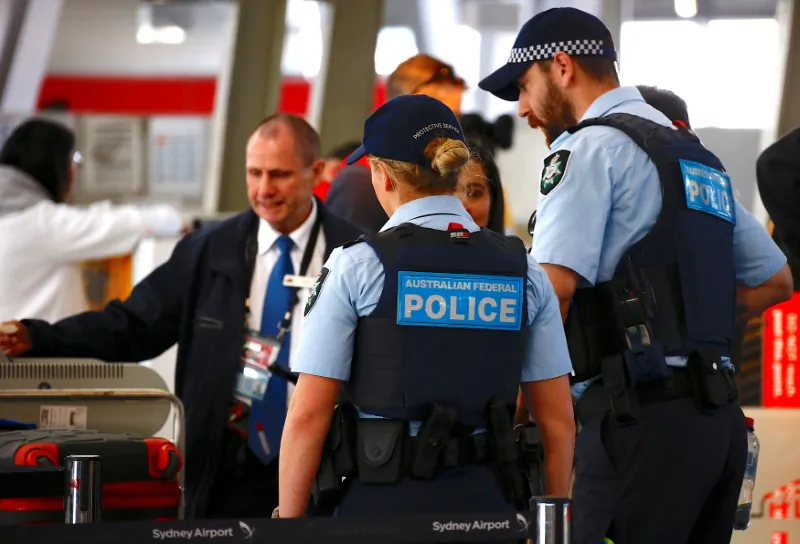 Australian Federal Police officers talk with passengers near the check-in counters at the Sydney Airport Domestic terminal in Australia, July 30, 2017. (Reuters/David Gray)