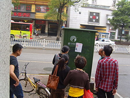 Local residents reading notice that demands an independent autopsy for Xu Chensheng and that the pepetrators be brought to justice. (Minghui.org)