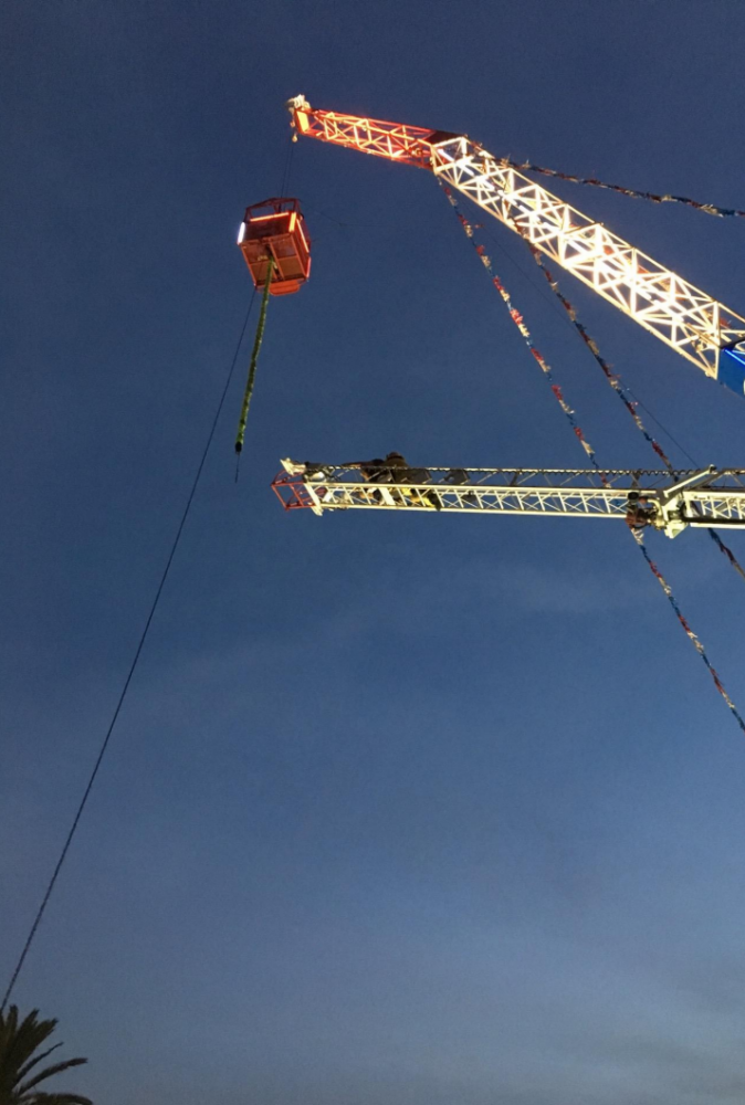 Fire fighters use ropes to rappel down a ride operator and customer from a cage suspended by a crane at the Ventura City County Fair on Aug 2. (Ventura City Fire Dept.)