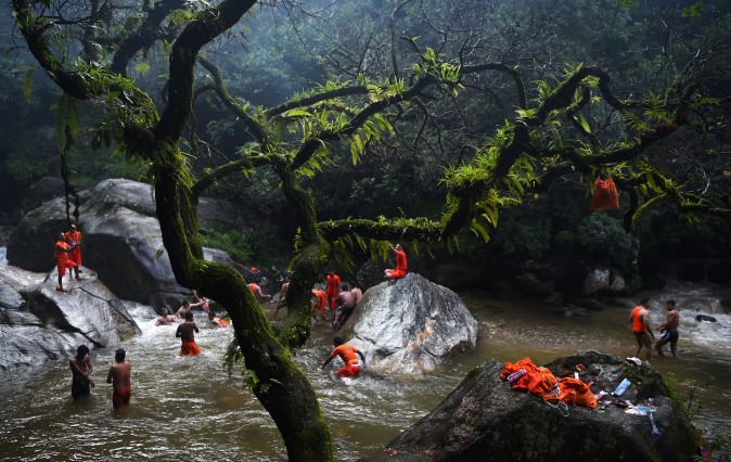 Hindu devotees bath and collect water in the Bagmati river on the outskirts of Kathmandu, Nepal, on Aug. 7, 2017. (PRAKASH MATHEMA/AFP/Getty Images)
