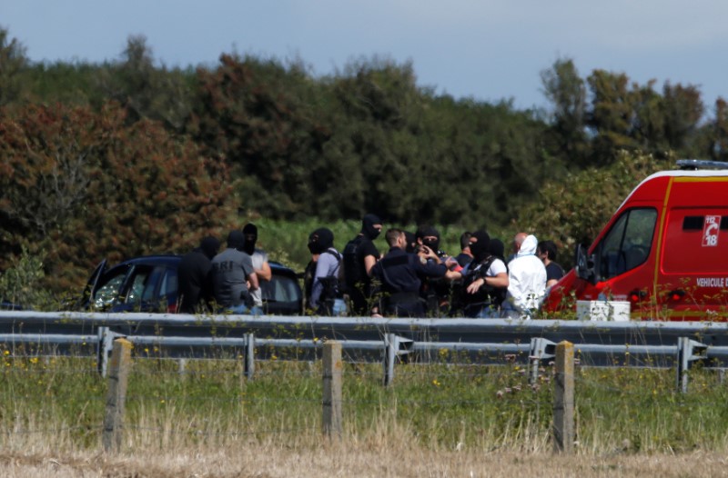 Police and rescue forces surround a BMW car with several bullet impacts in it at the scene where the man suspected of ramming a car into a group of soldiers on Wednesday in the Paris suburb of Levallois-Perret was shot and arrested on the A16 motorway, near Marquise, France, August 9, 2017.  REUTERS/Pascal Rossignol