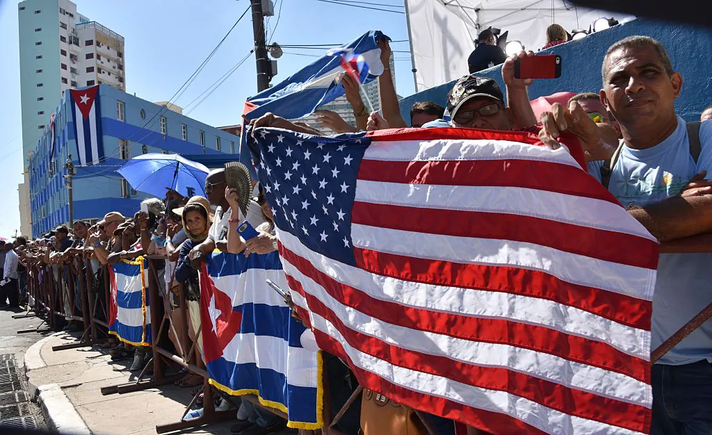 Cubans hold U.S. and Cuban flags outside the U.S. Embassy building as the U.S. flag is raised over it in Havana. (Adalberto Roque/AFP/Getty Images)
