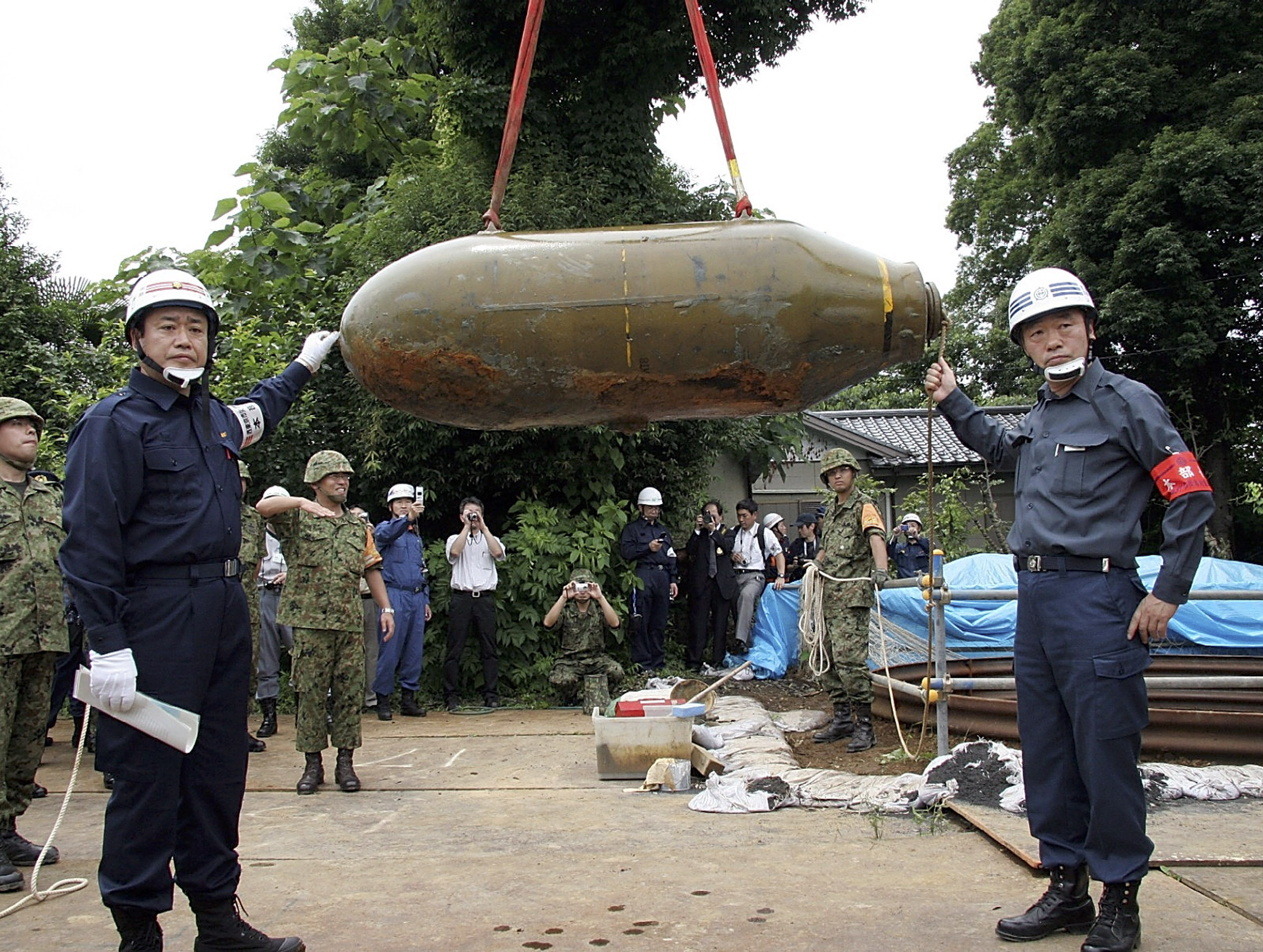 Japan's Ground Self Defence Forces remove an unexploded 1-tonne bomb which was supposedly dropped by the U.S. military during the WWII on July 10, 2005 in Nishitokyo, western Tokyo, Japan. (Nishitokyo City via Getty Images)
