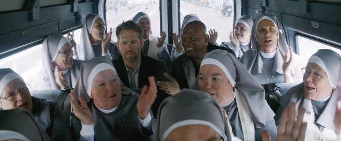 (L–R) Darius Kincaid (Samuel L Jackson), and Michael Bryce (Ryan Reynolds) among a plethora of nuns in 