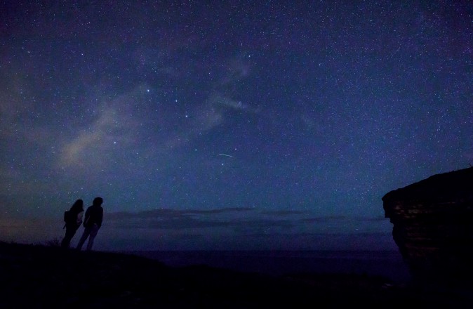 A couple watches the Perseid meteor shower along the Milky Way illuminating the dark sky near Comillas, Cantabria community, northern Spain, on Aug. 13. Northern hemisphere sky-gazers are in for a special treat on August 11 and 13, night with a rare shooting star "outburst", which astronomers hope will not be marred by clouds and a bright Moon. (CESAR MANSO/AFP/Getty Images)
